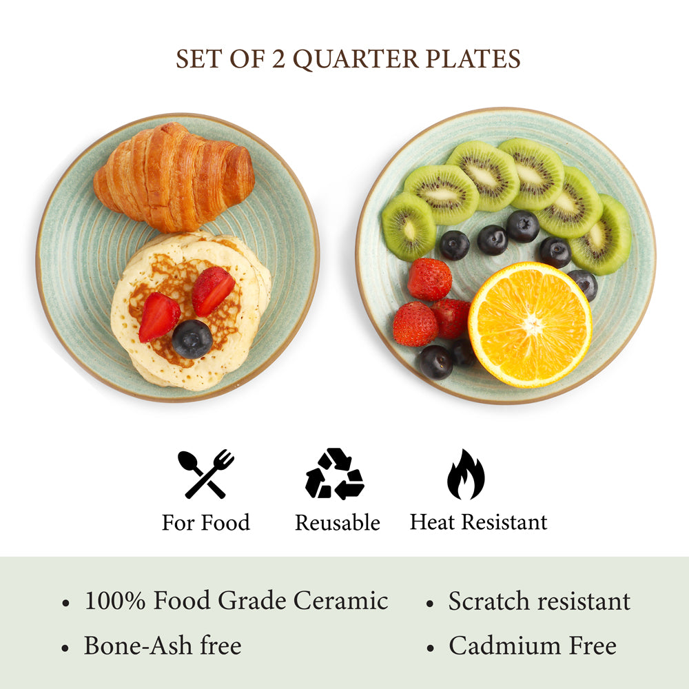 Set of two quarter plates with food, featuring a croissant and pancakes on one plate, and fresh fruits like kiwi, orange, and berries on the other.