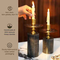 Elegant black and gold candlestick holders with lit candles on a wooden table. — thumbnail