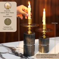 Elegant black and gold candlestick holders with lit candles on a wooden table. — thumbnail