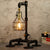 This industrial-style desk lamp features a creative plumbing pipe design and a retro cage bulb holder, blending vintage aesthetics with modern functionality.