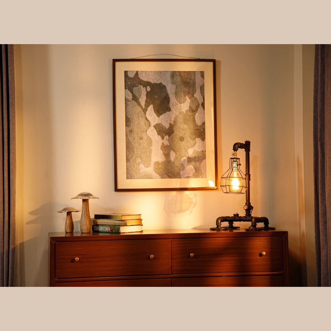 This industrial-style desk lamp features a creative plumbing pipe design and a retro cage bulb holder, blending vintage aesthetics with modern functionality.