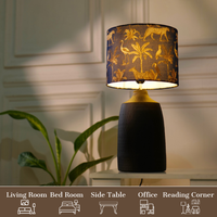 Elegant table lamp with colorful artistic shade on wooden base, placed on a desk — thumbnail