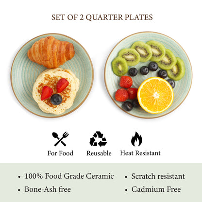 Set of two quarter plates with food, featuring a croissant and pancakes on one plate, and fresh fruits like kiwi, orange, and berries on the other. 