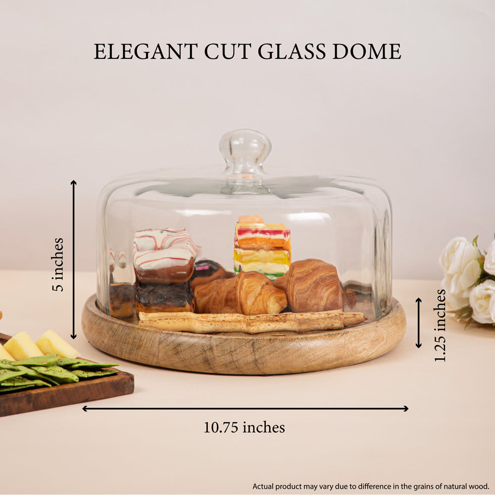 Elegant cut glass dome measuring 10.75 inches in diameter and 5 inches in height, placed on a wooden base displaying pastries