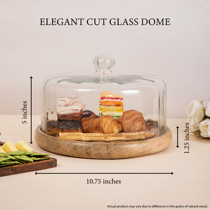 Elegant cut glass dome measuring 10.75 inches in diameter and 5 inches in height, placed on a wooden base displaying pastries